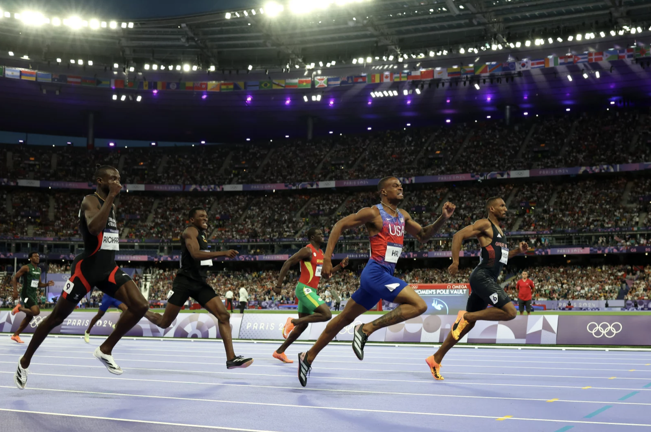 Five Olympic runners sprinting down a track.