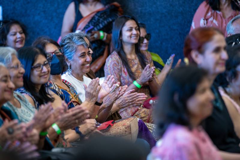 Audience members smile and clap.