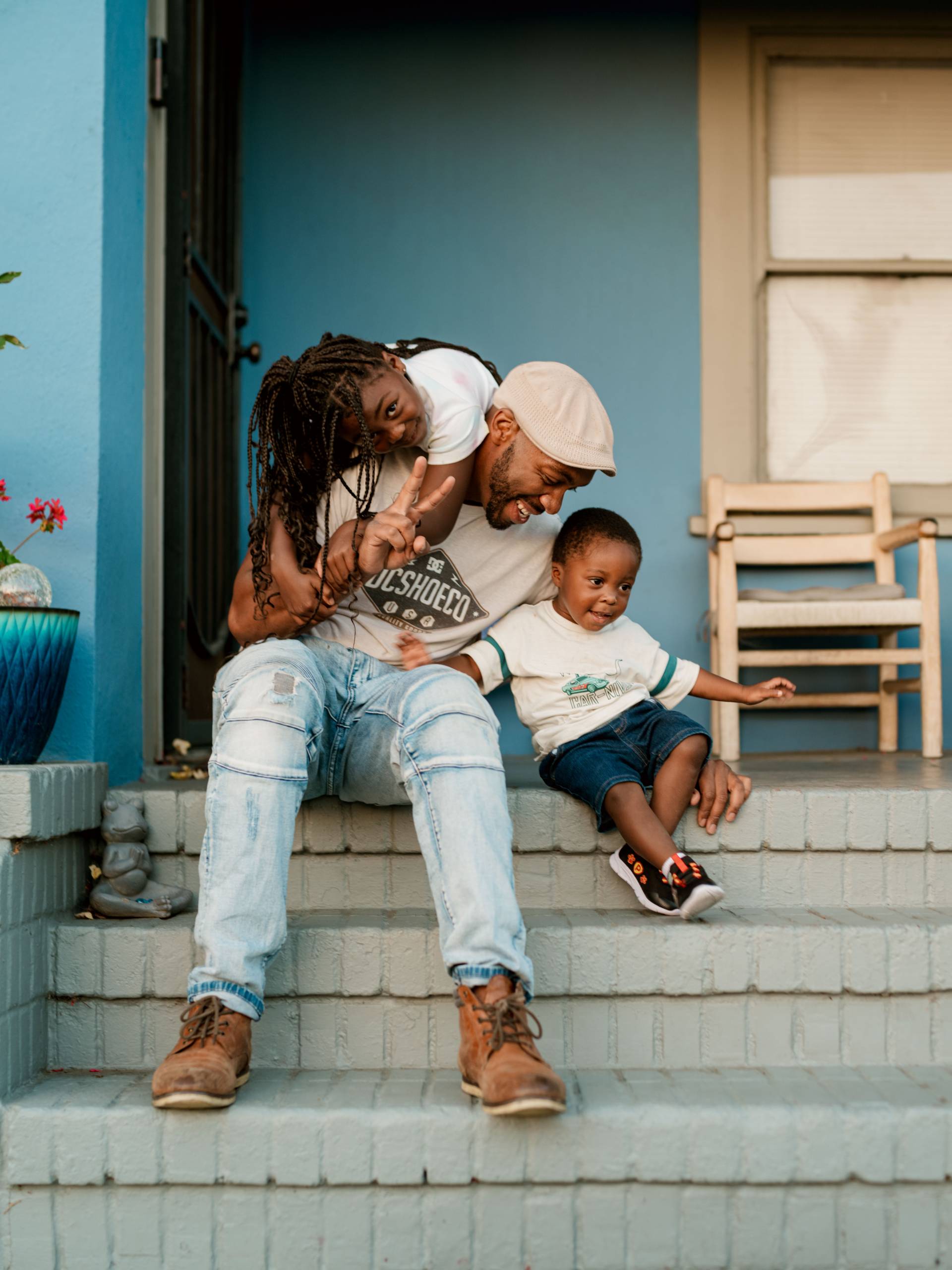 a father plays on the porch with his two children