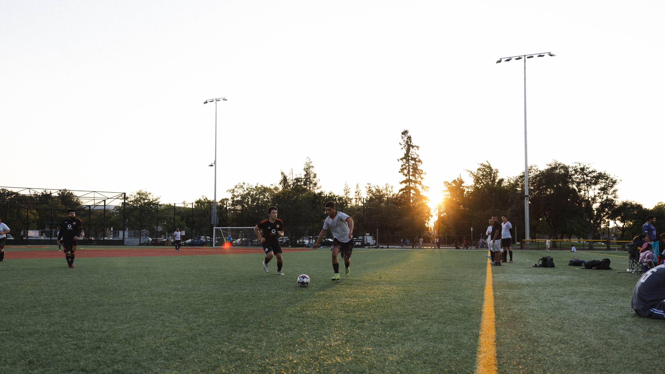 two players chase the ball during a local soccer game