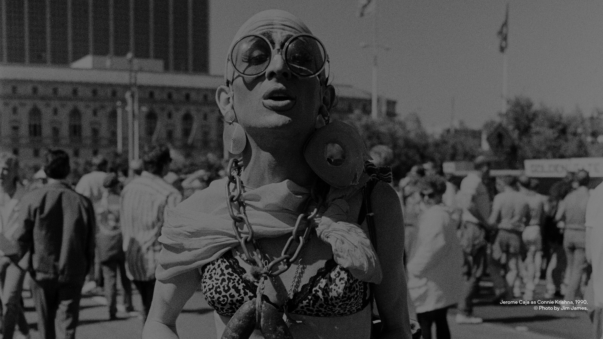 black and white image of a person in drag in sunglasses in public square