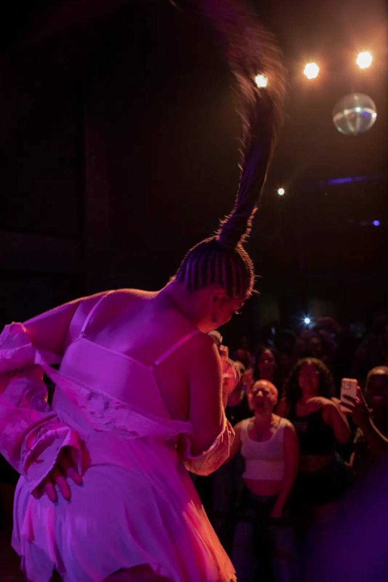 Qing Qi on the mic, letting her hair take to the air, during a birthday performance.