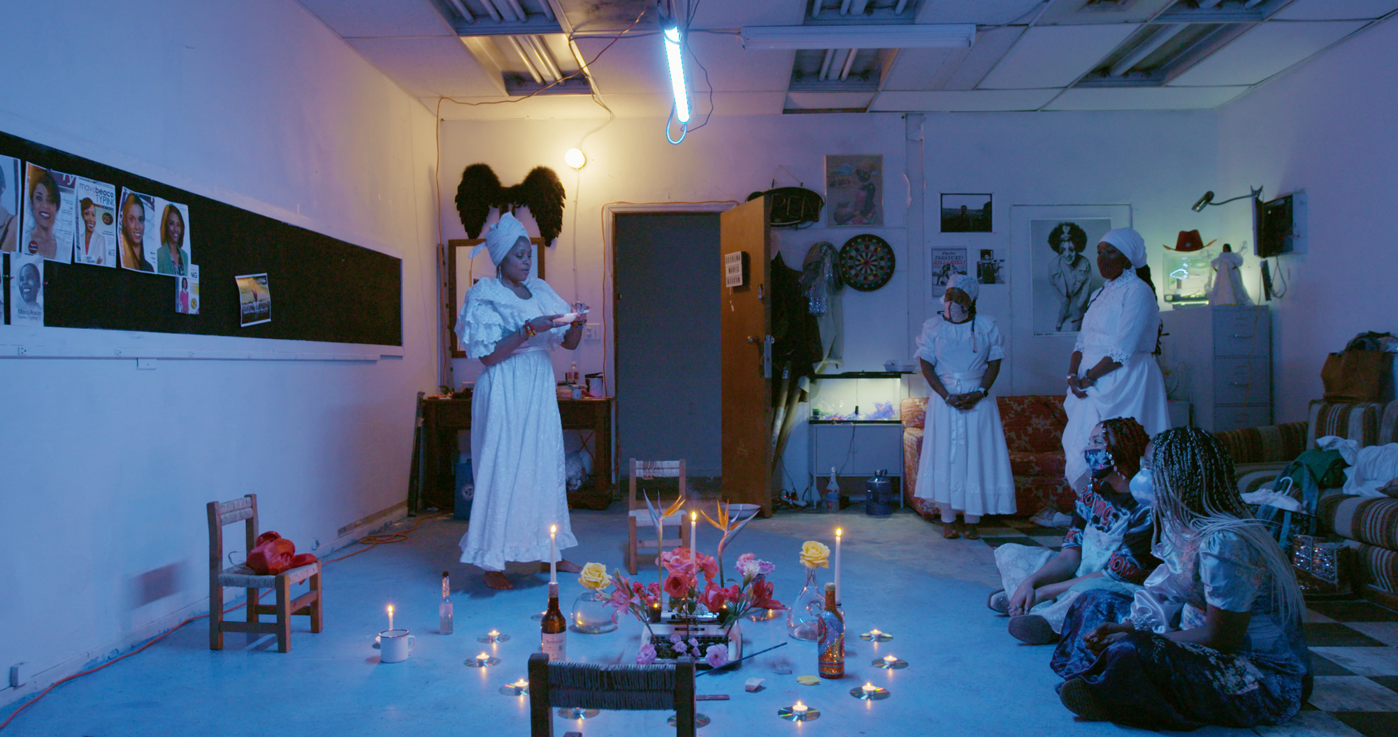 Black women stand around a circle of candles