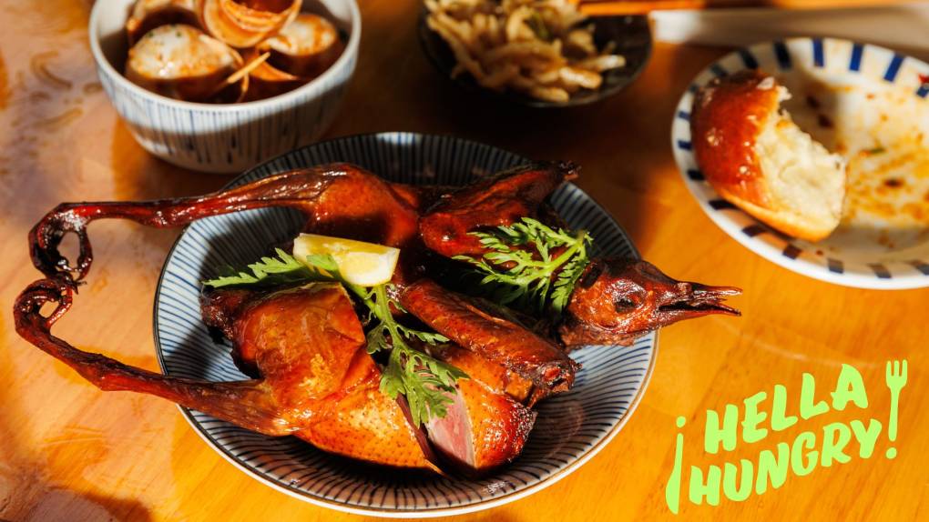 Spread of Cantonese dishes including whole fried squab with head and feet attached.