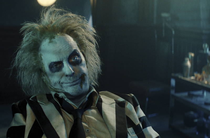 A ghoulish looking man with unkempt hair and striped suit.