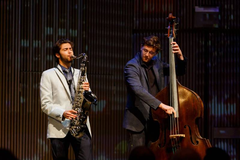 Sax player and upright bassist perform on stage