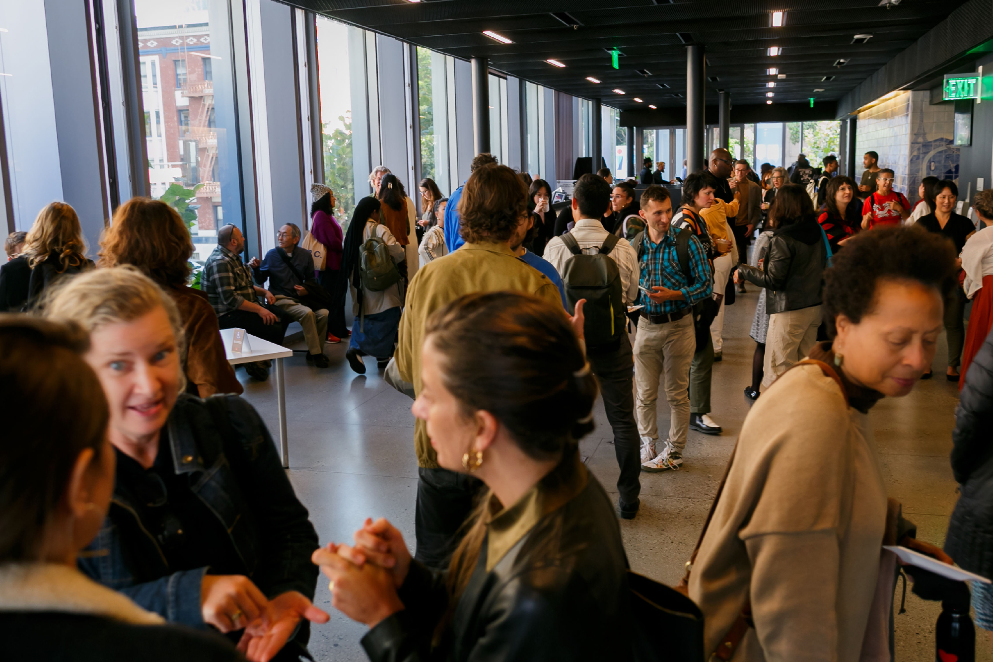 crowd in spacious lobby area with windows on one side