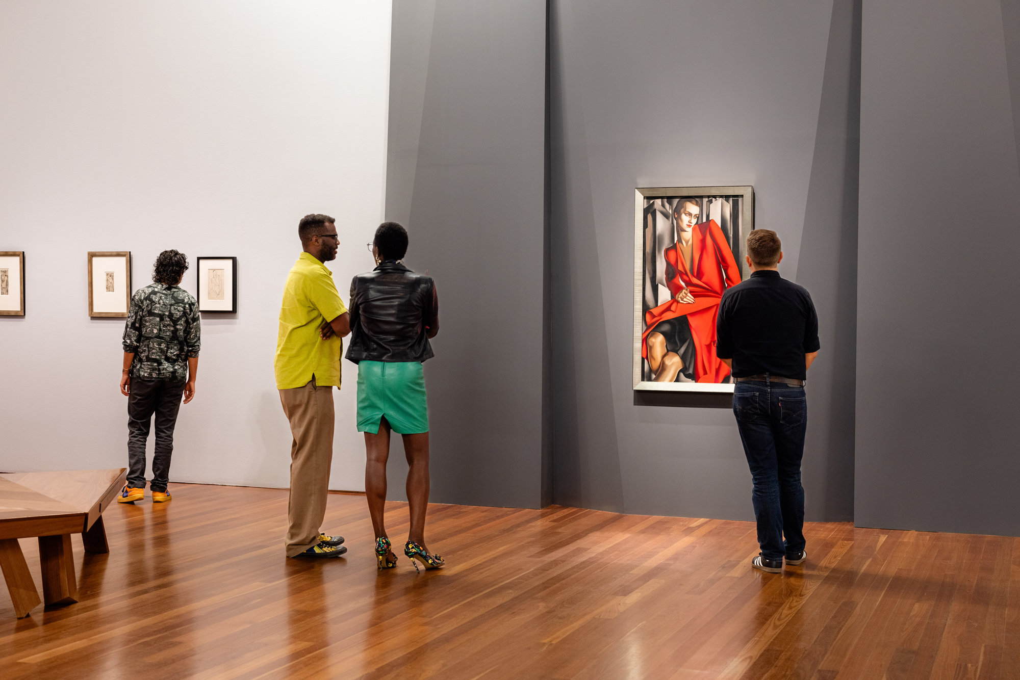 gallery view with people looking at paintings on walls