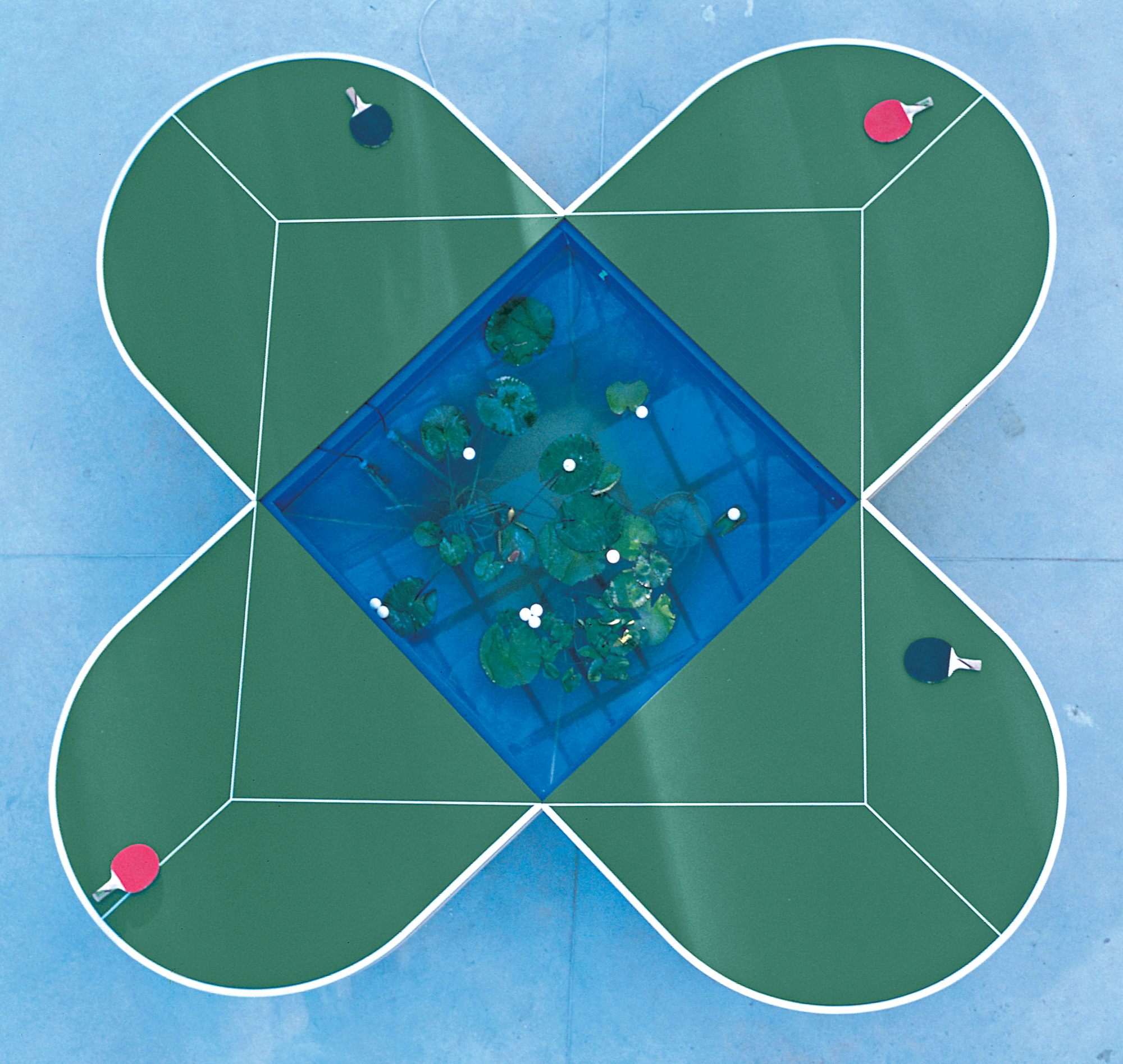 overhead view of clover-shaped ping-pong tables with pond at center