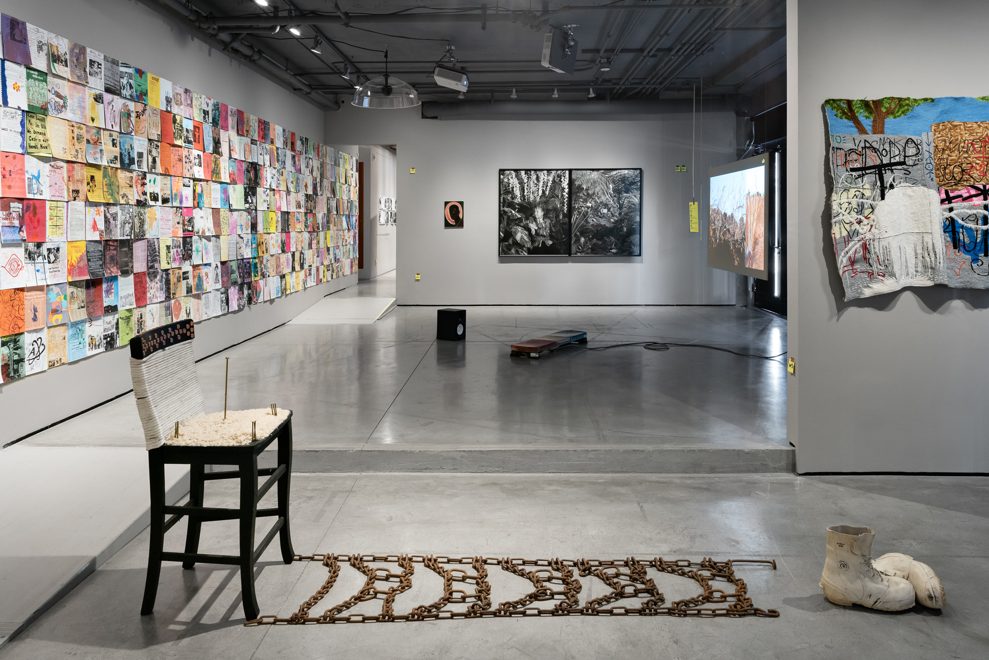 gallery view with lots of art on walls, chair sculpture in foreground