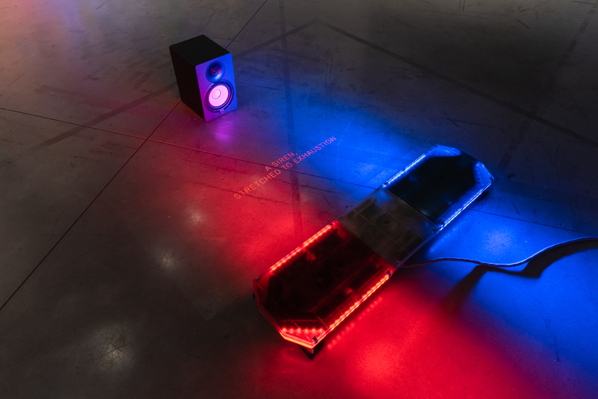 small speaker on floor next to red and blue light bar