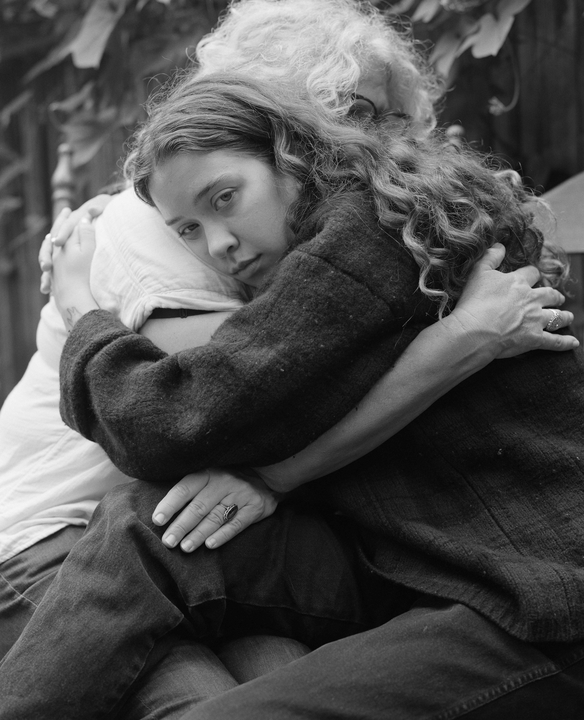 black-and-white photo of a young person hugging an older person