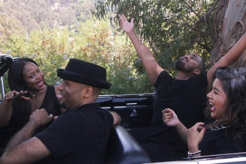 The cast of 'The Joy Ride' on set, inside of a vintage convertible car.