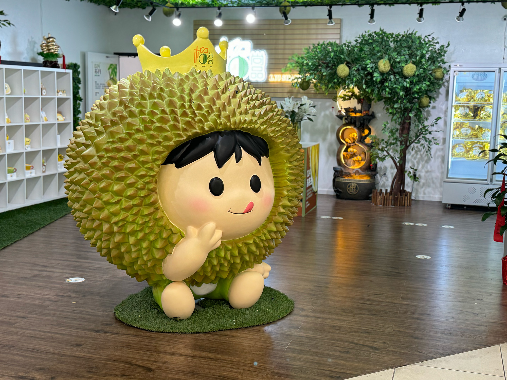 A giant, plastic "durian king" mascot with a spiky shell and a crown on his head.