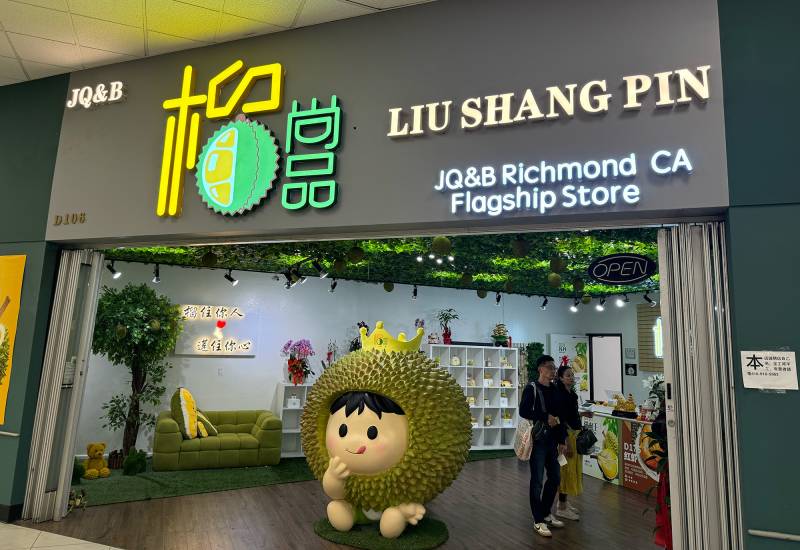 Store facade for Liu Shang Pin, a durian specialty store with a giant 'durian king' mascot in front.