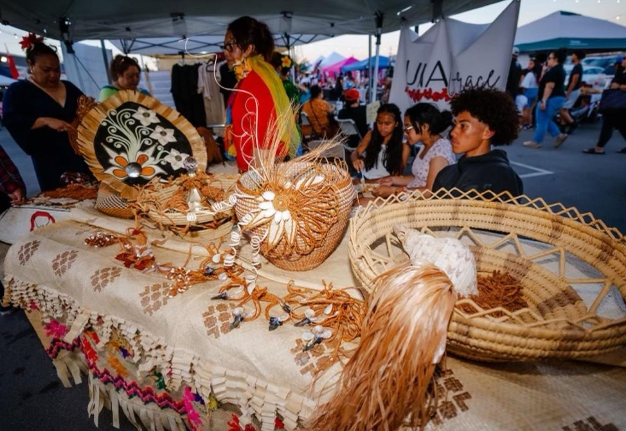 A vendor selling traditional woven crafts at a Pacific Islander festival.