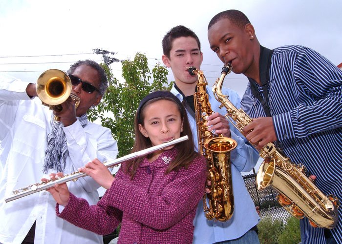 Oaktown Jazz Workshops’ late Founding Director Khalil Shaheed poses next to a handful of students, as they all hold an assortment of instruments, circa 2008.