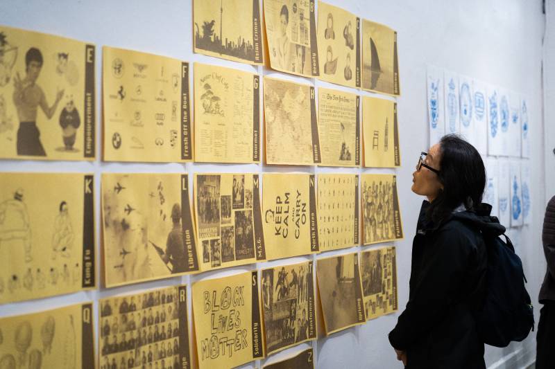 woman looks at rows of yellow printed paper