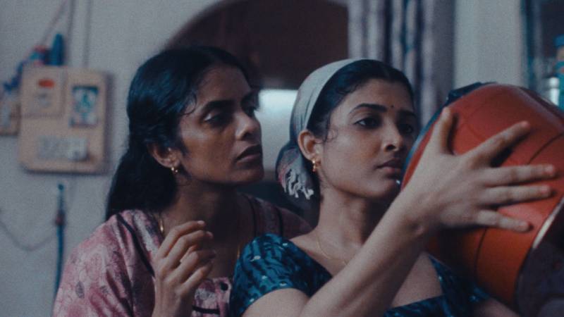 two south asian women look into a rice cooker