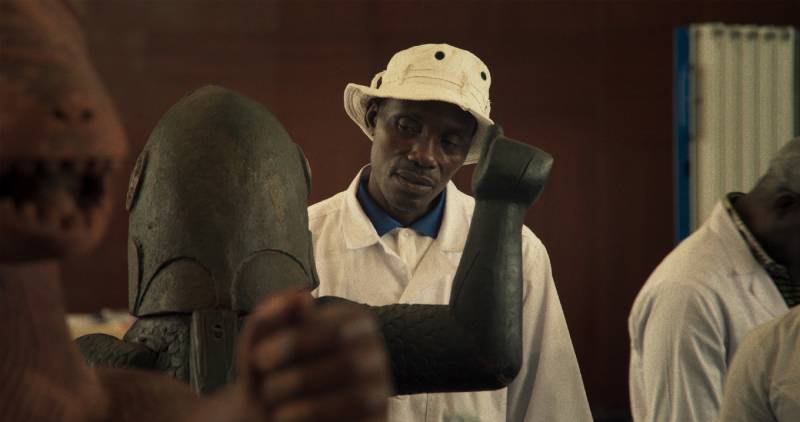 Black man looks at figurative statues