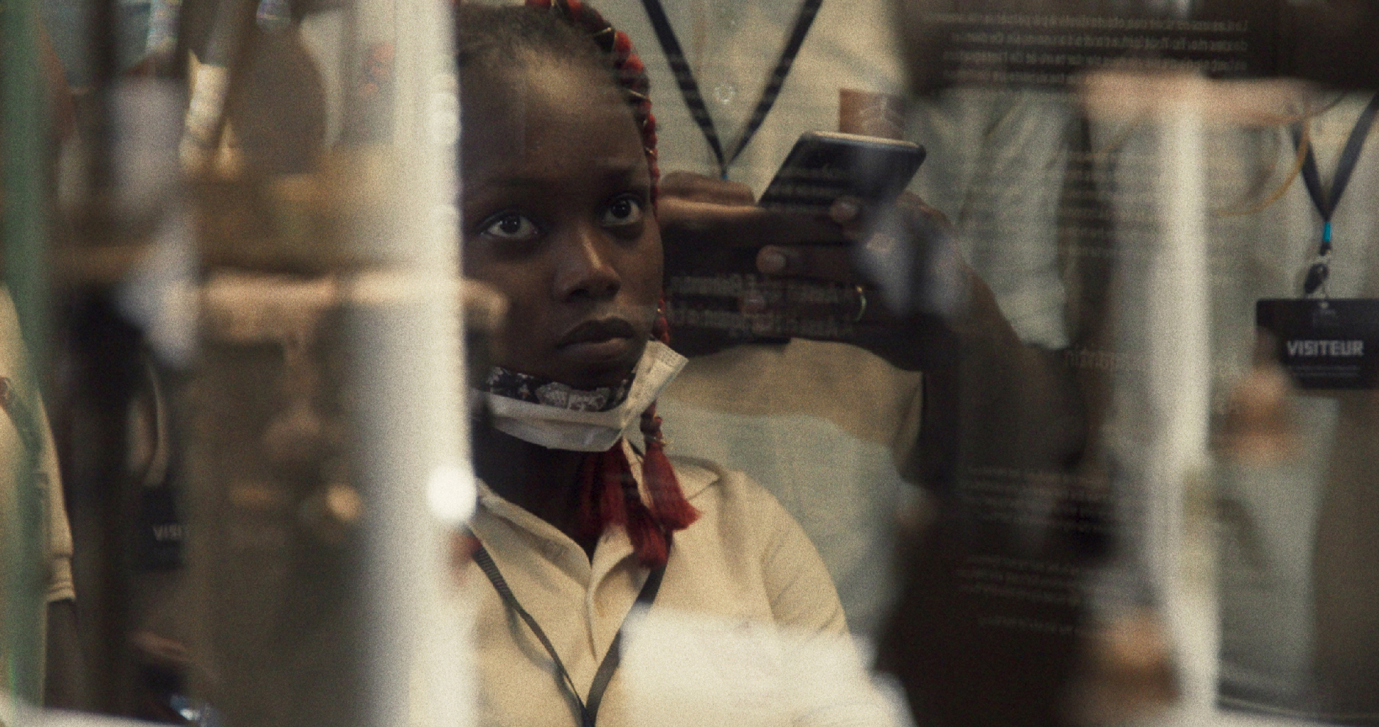 girl looks through glass in school uniform