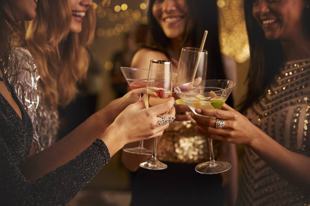 Four female friends make a toast at a party.