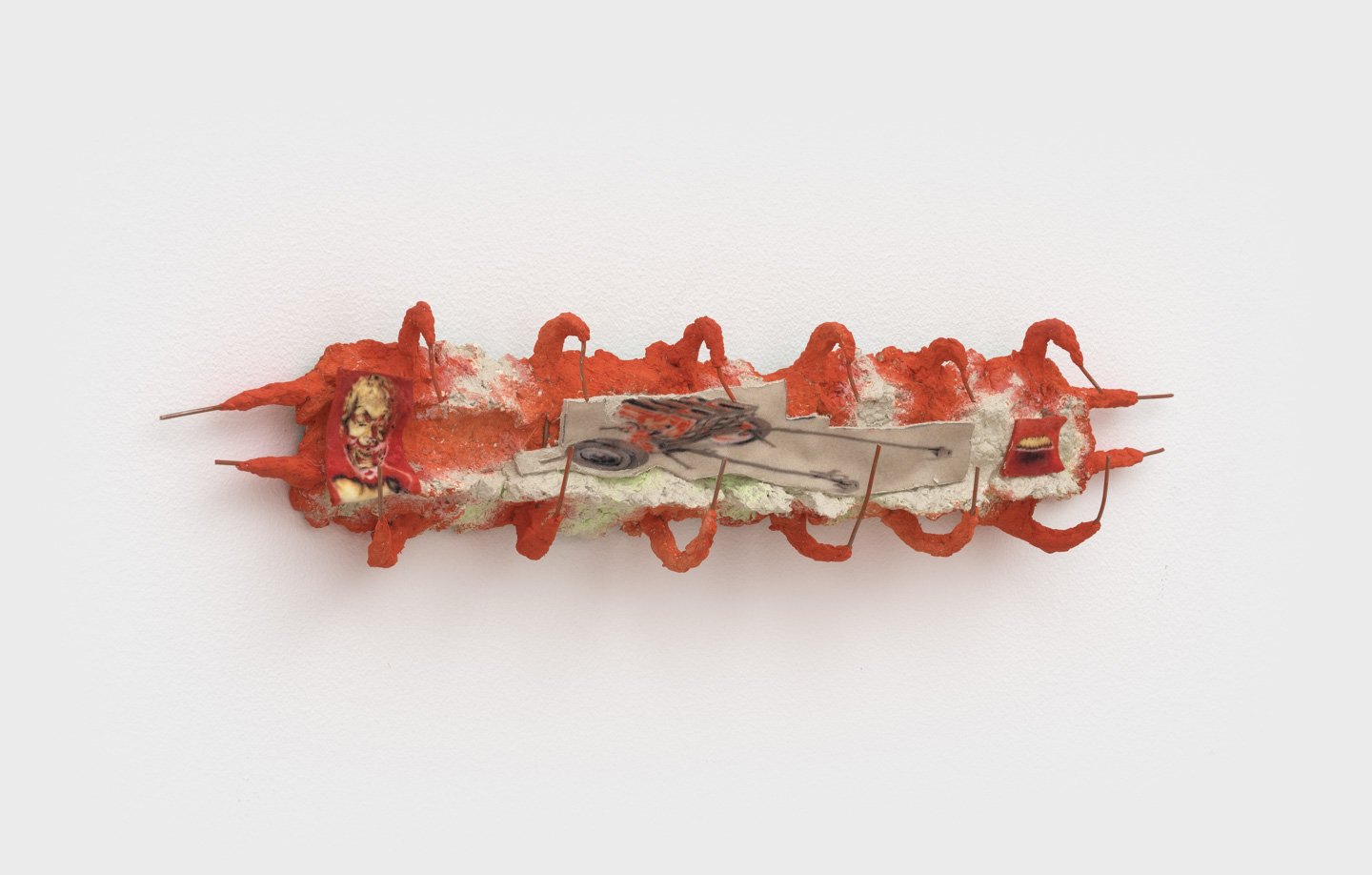 horizontal sculpture with wire painted red, small felt images inside spine-like shape