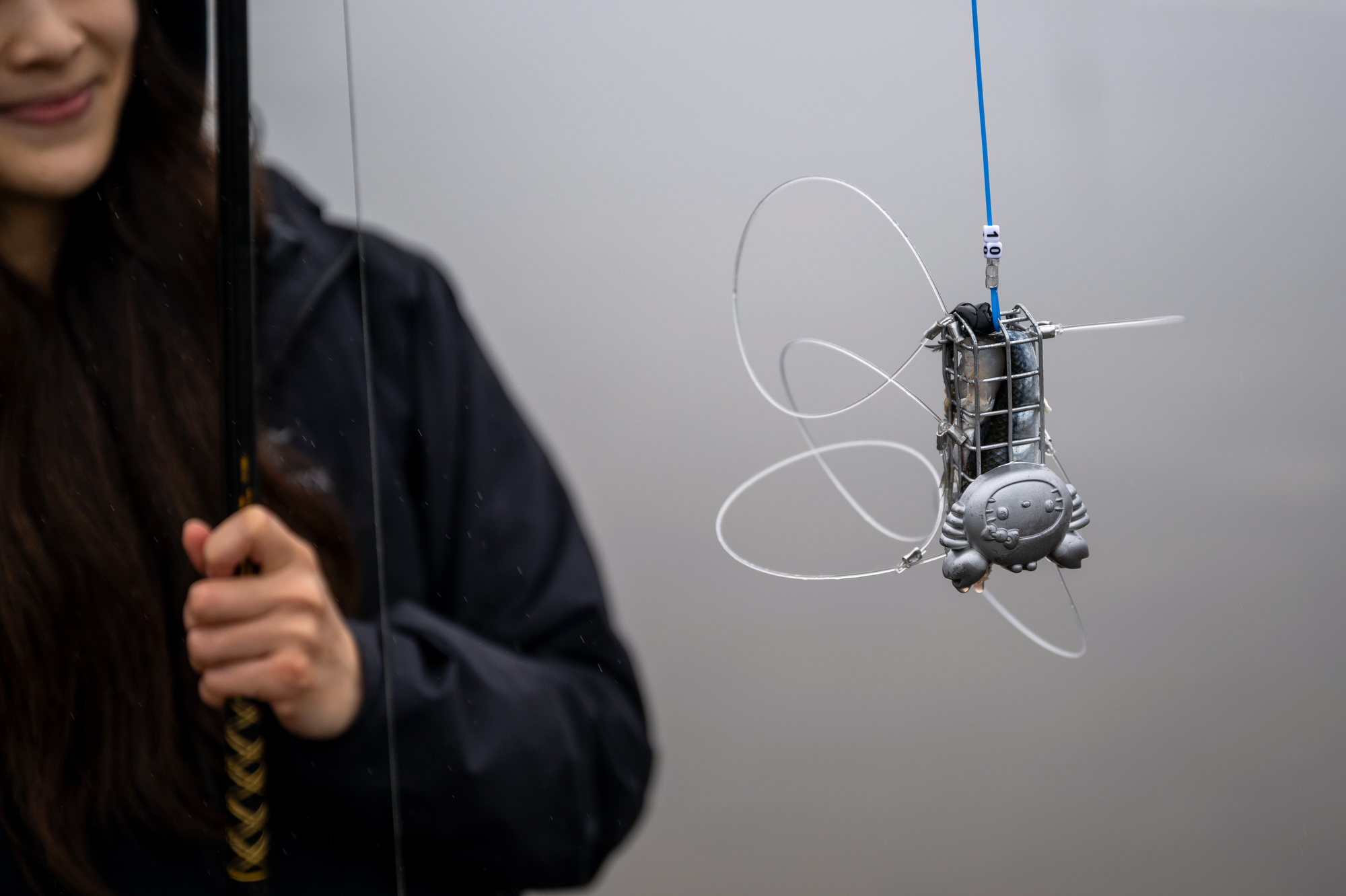 A fisherman shows off her snare trap, which is made to look like Hello Kitty.