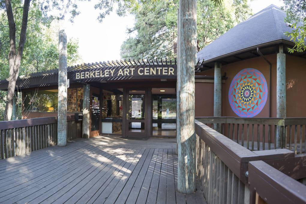 dark wooden structure with name of art center over door, trees in background