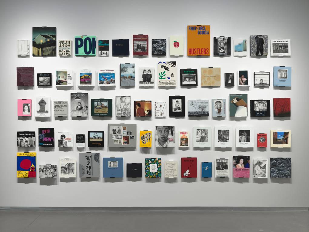 painted replicas of books mounted to wall in large grid