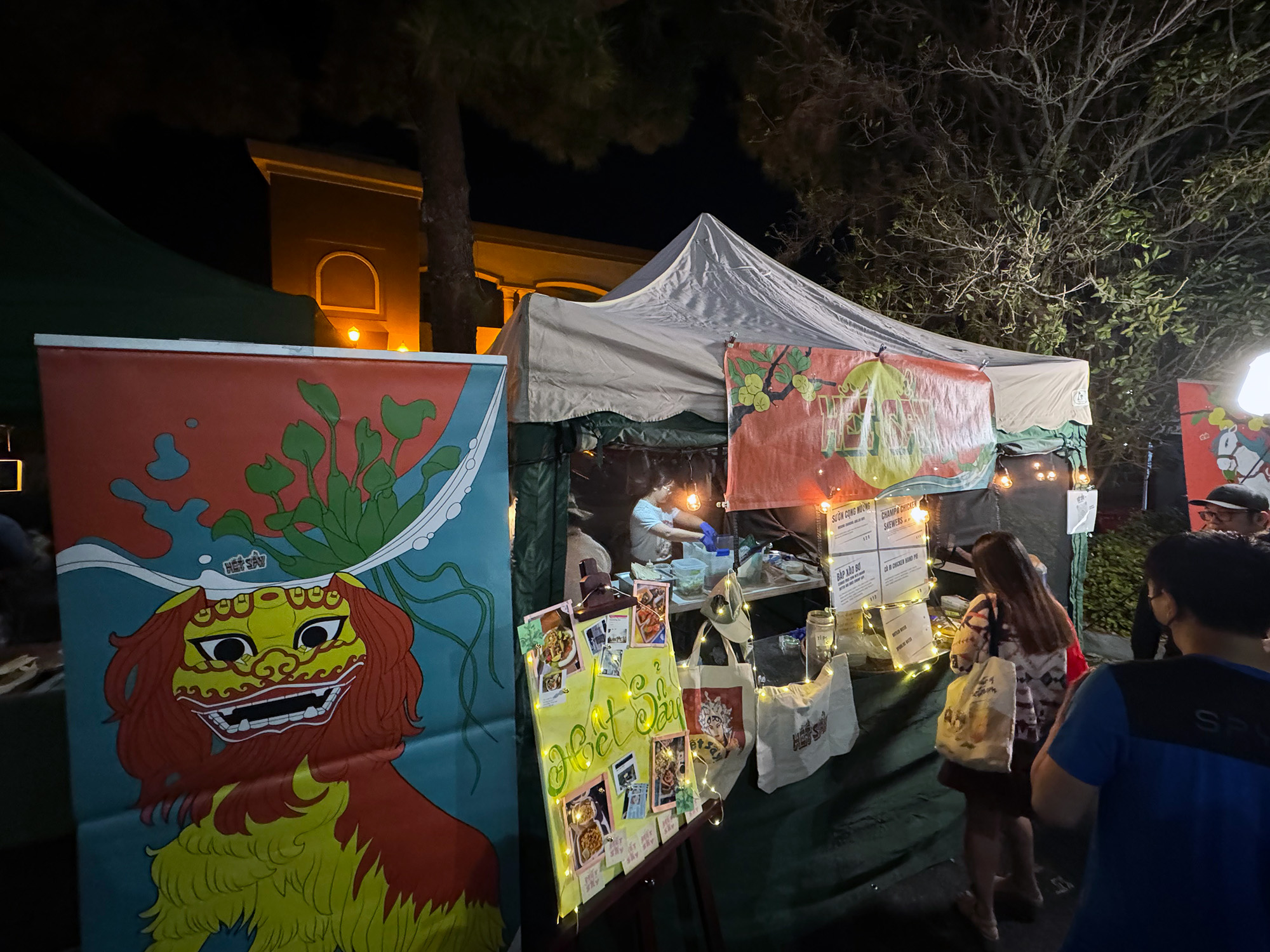 A night market stall with a hand-written sign that reads, "Het Say."