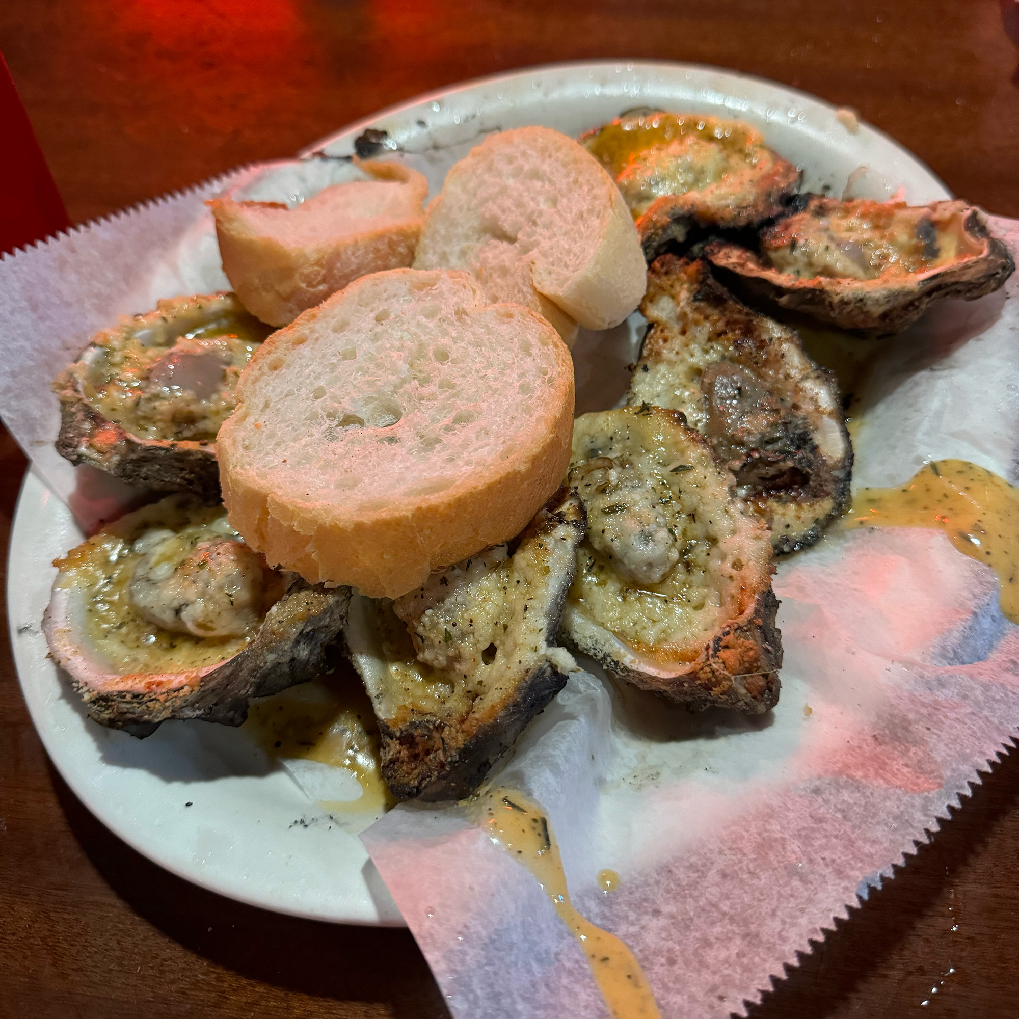 Grilled oysters topped with rounds of bread.