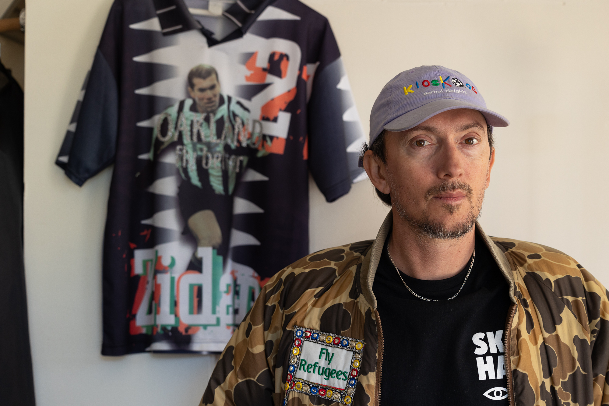 man poses in camo jacket and hat