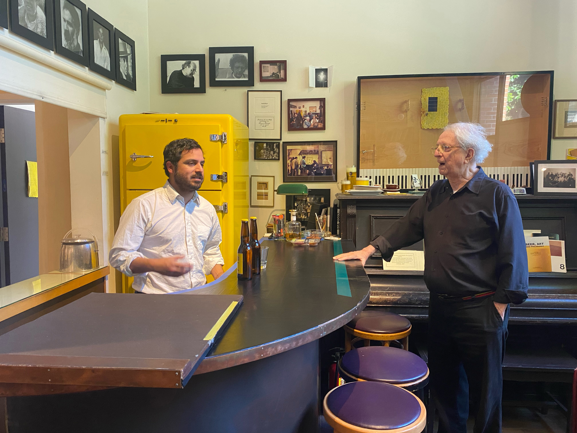 younger man and older man face each other over bar and bar stools