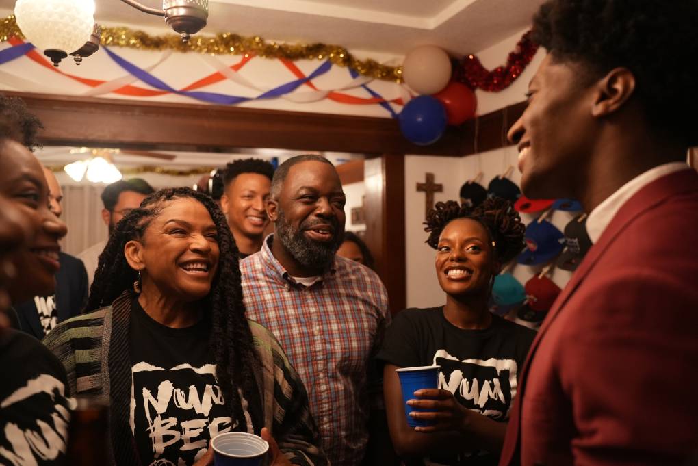 Black family members smile in house decorated for party