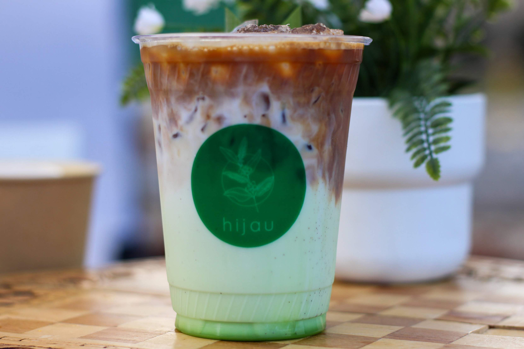 Iced coffee drink mixed with green-tinted milk.