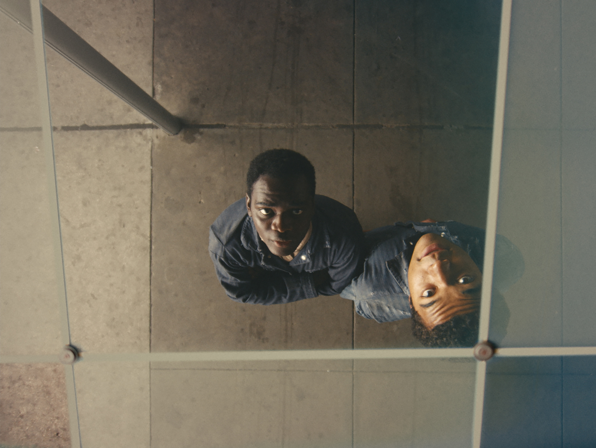two Black boys look up into mirrored ceiling