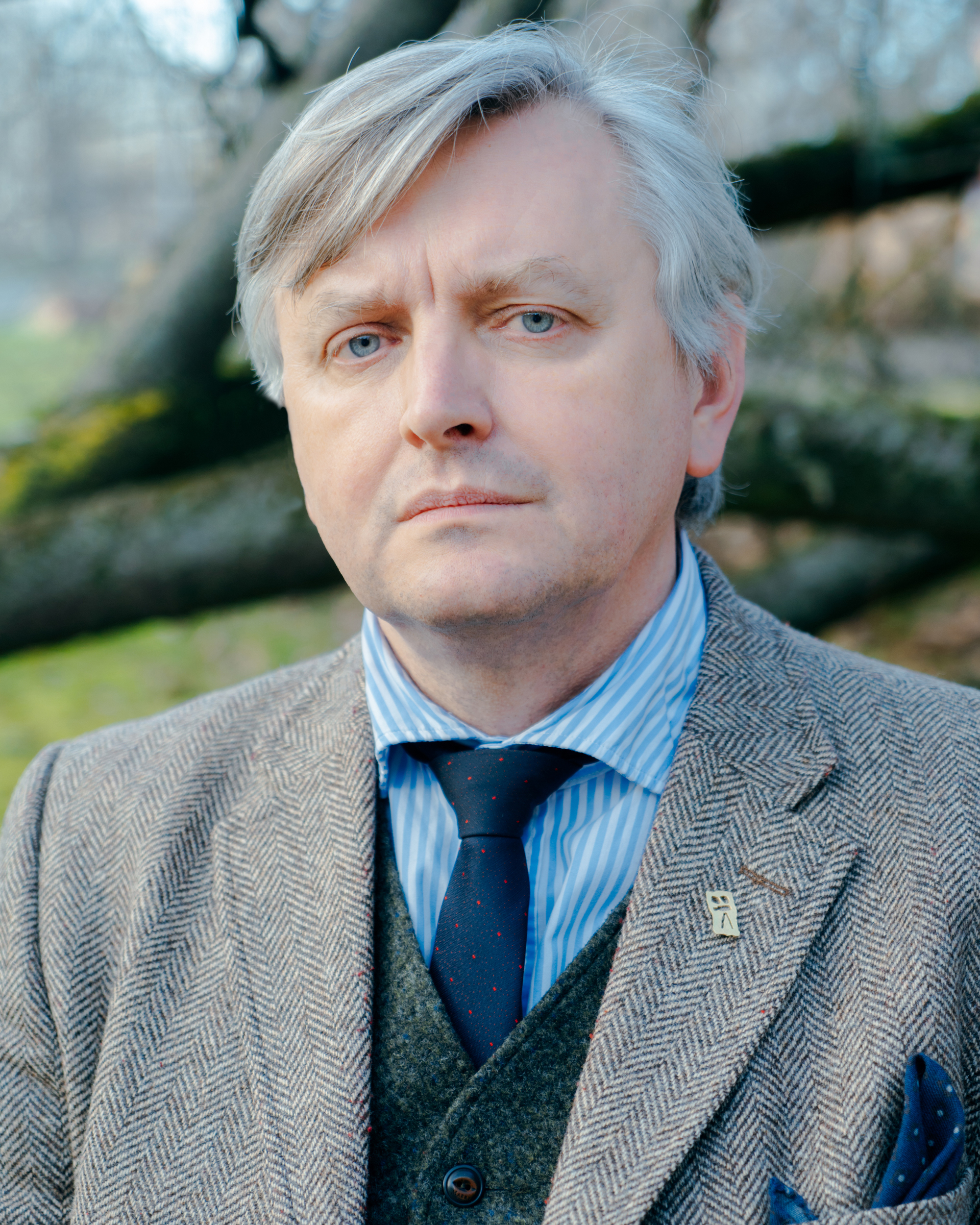 portrait of white man in suit and tie with gray hair