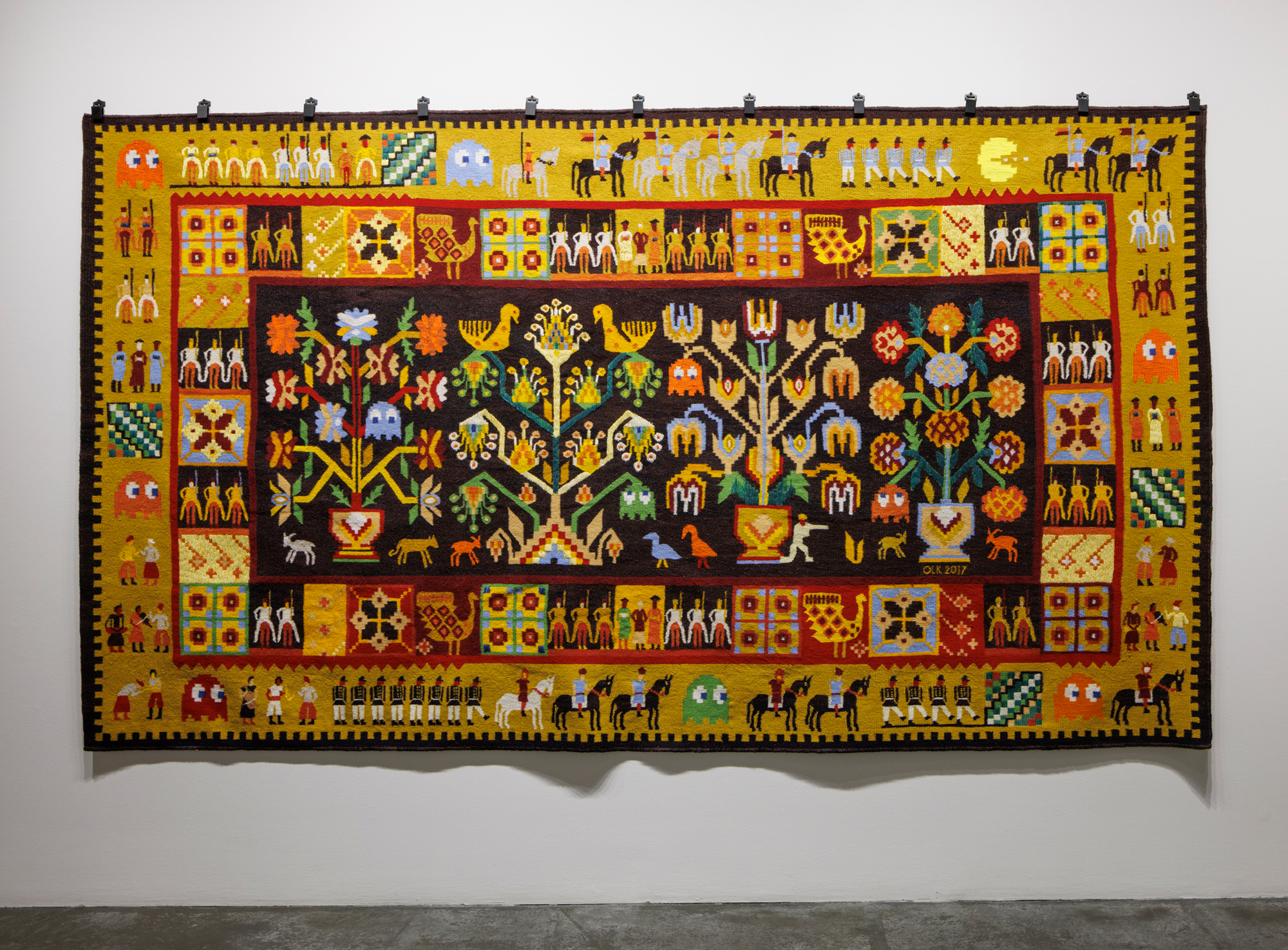 traditional-looking weaving with soldiers, plans and pac-man game characters