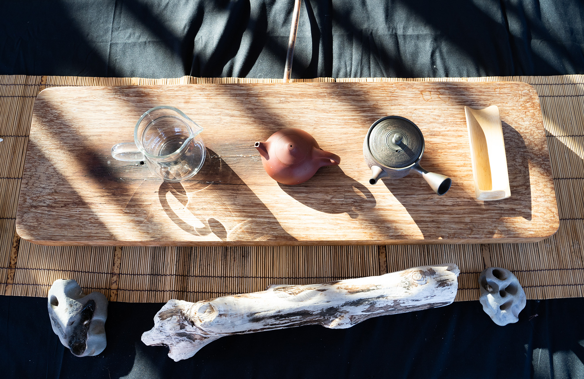 Traditional Chinese teaware laid out on a slab of wood.