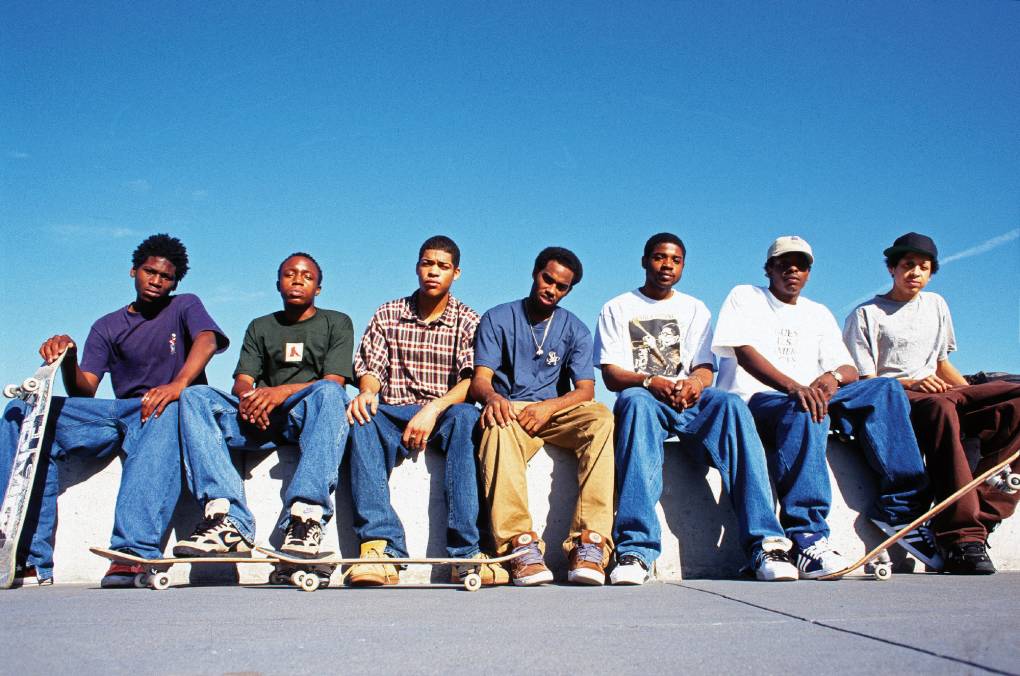 seven Black youths pose with skateboards