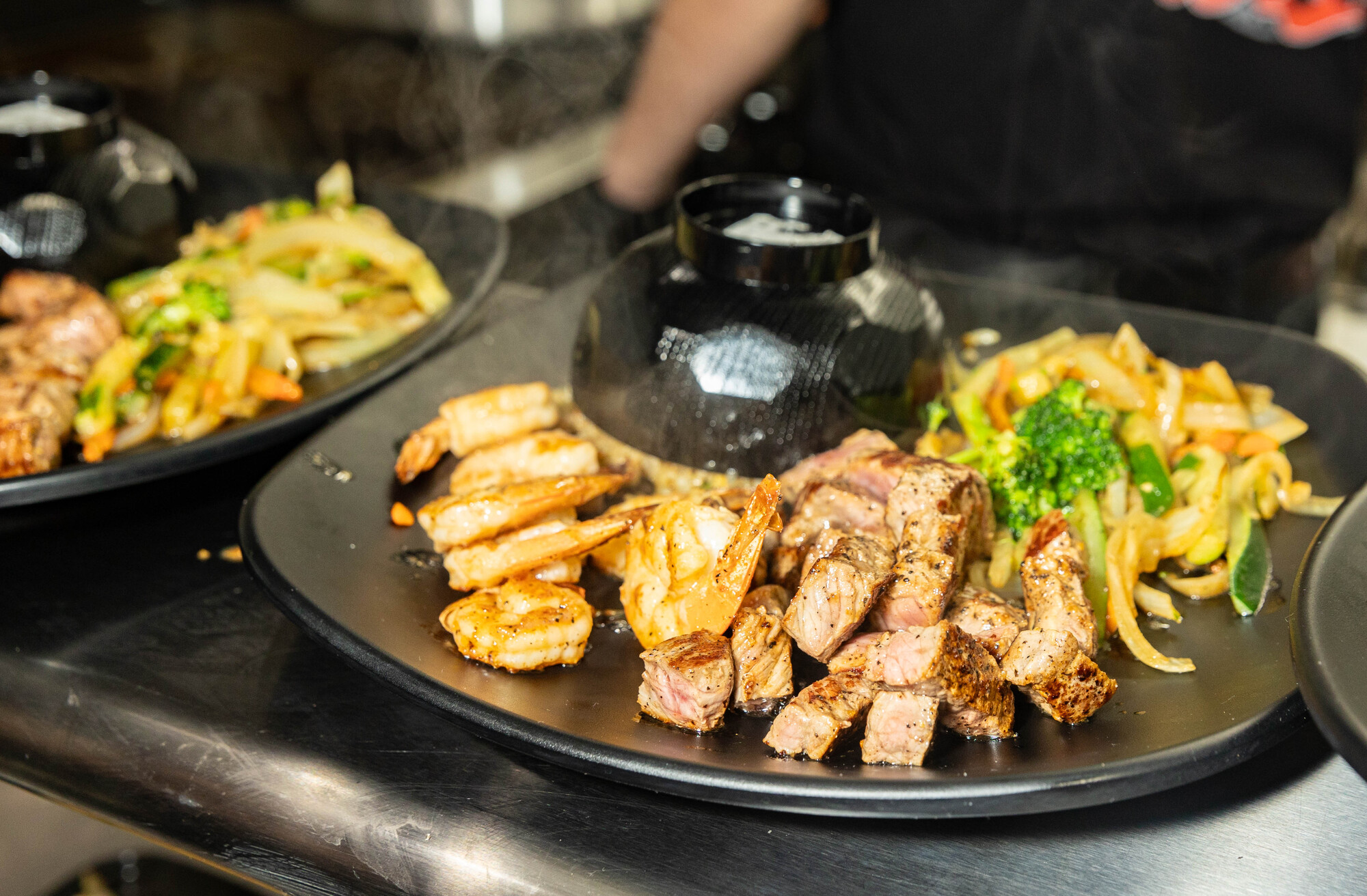 A plate of fried rice, steak, shrimp and grilled vegetables.