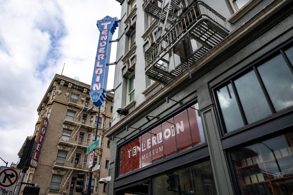 old corner building with 'tenderloin' neon sign attached, 'tenderloin museum' sign in window