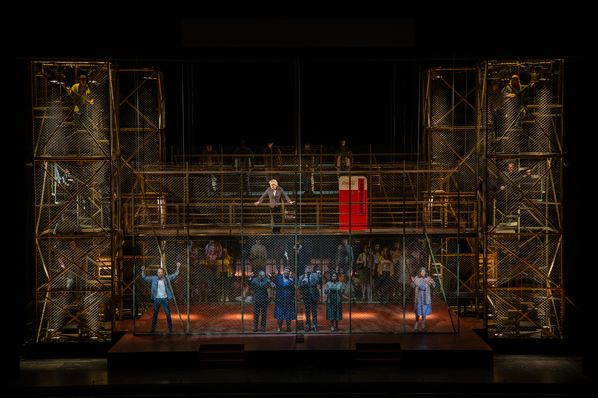 An opera set with fences and barbed wire that look like a prison.