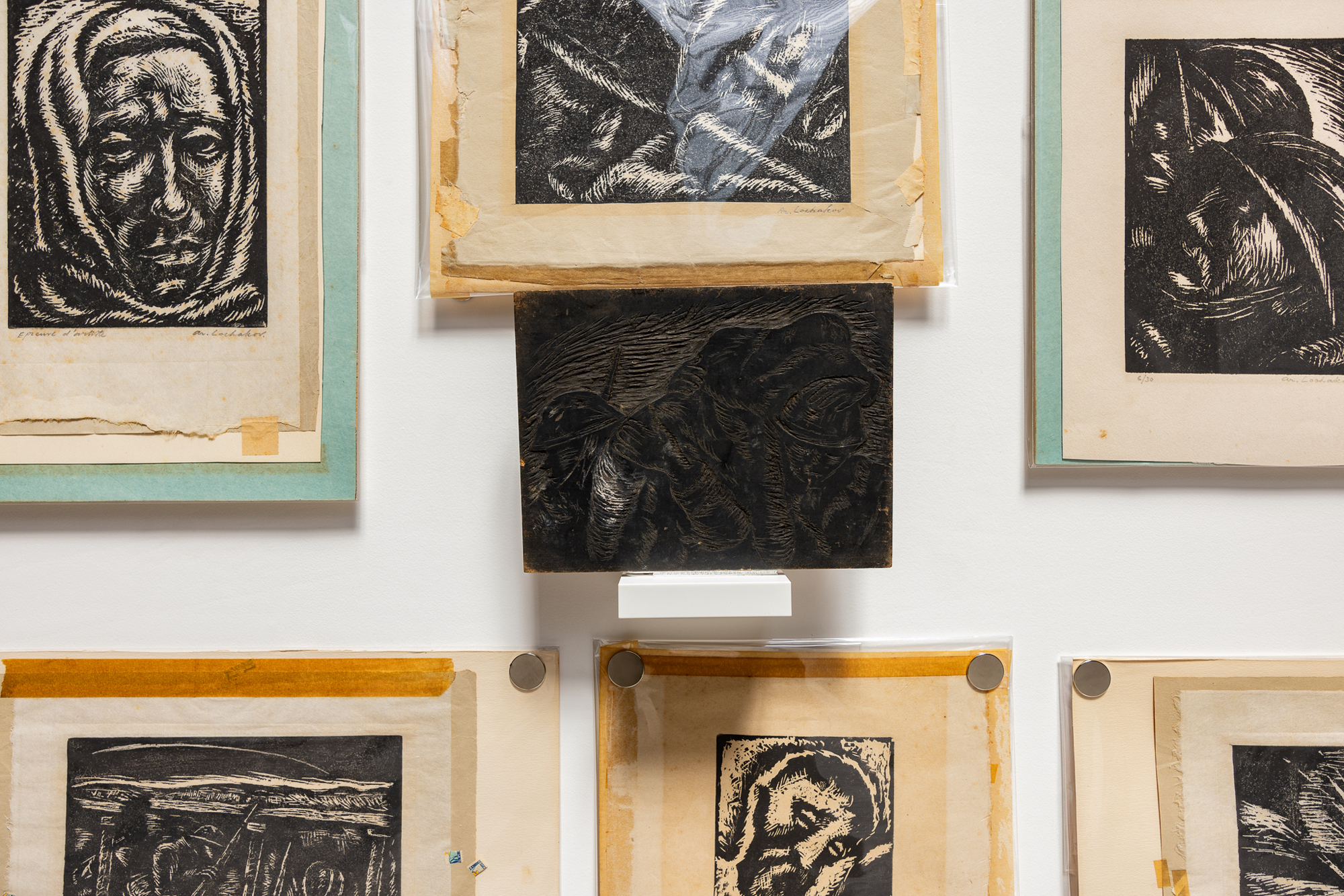 carved woodblock and prints on wall