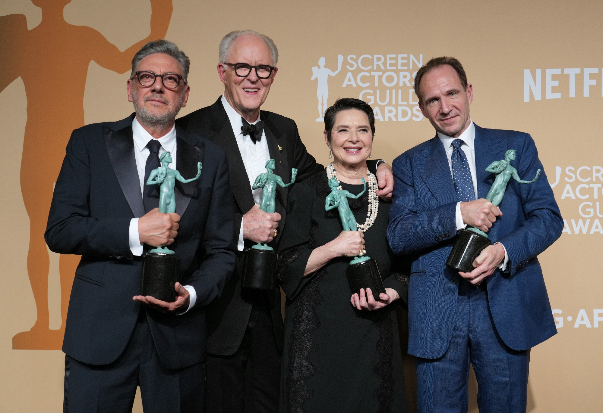Four men and one woman hold bronze statues