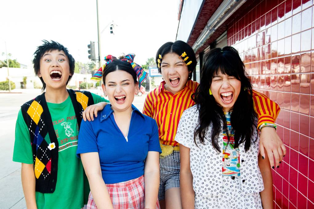four young women scream, mouths open