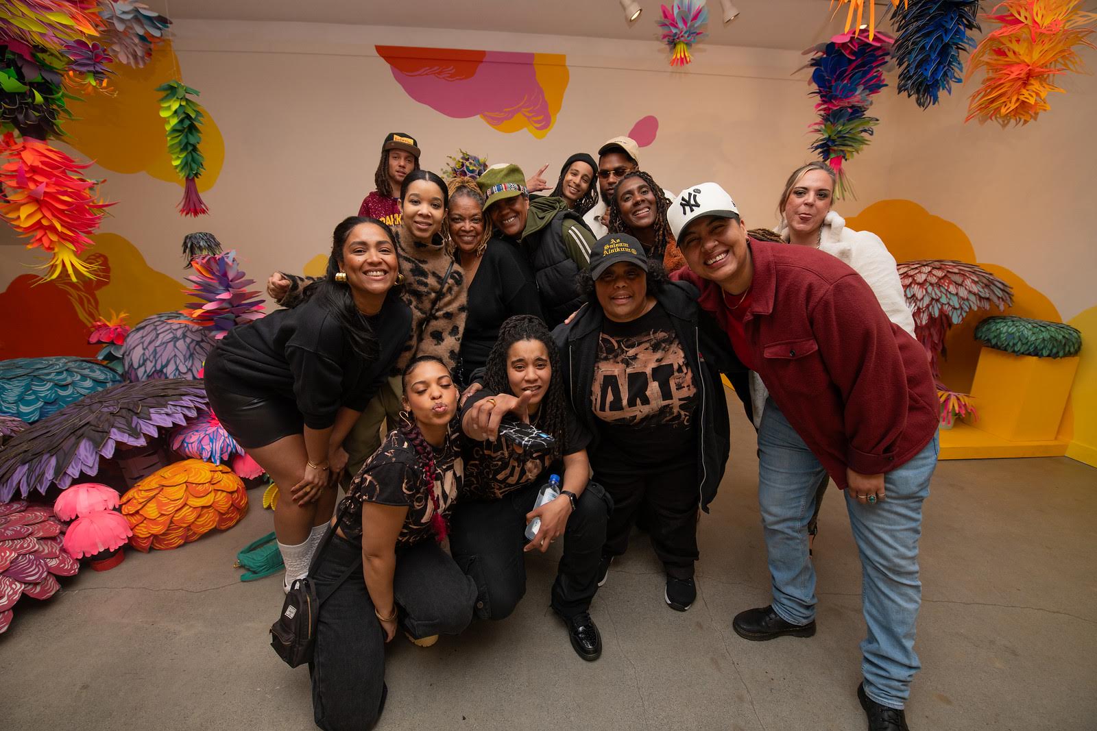 A group of people posing for a photo inside of an art gallery.