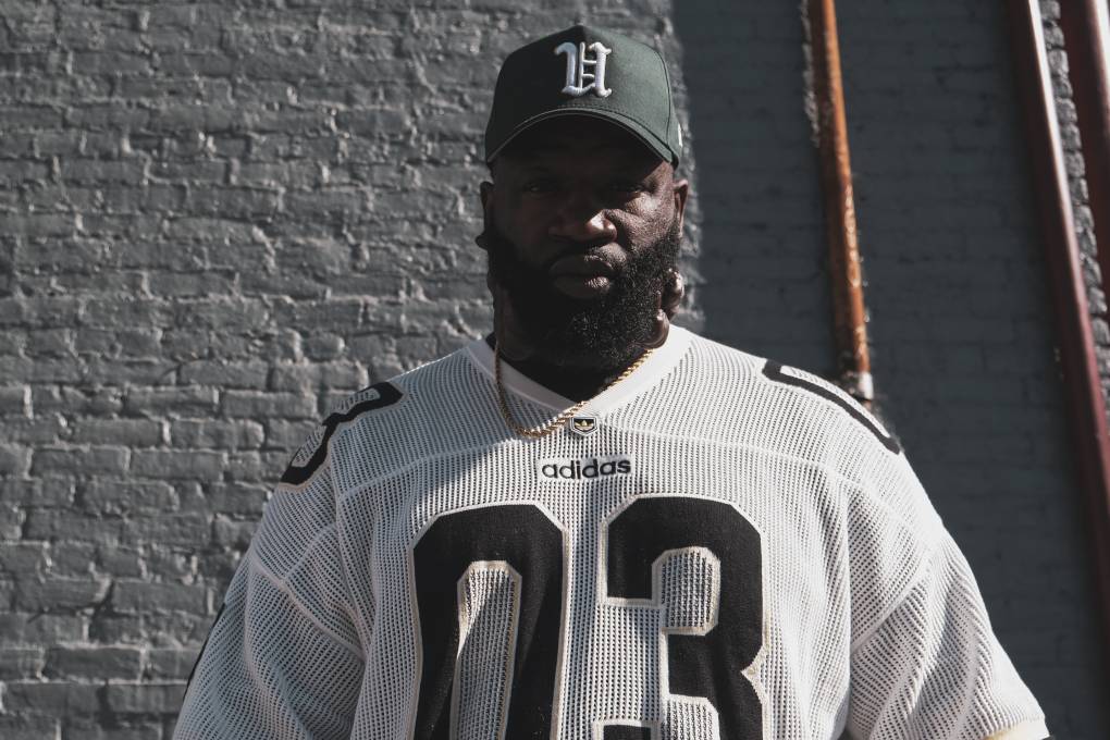 Man with a green hat and 03 football jersey poses for a photo.