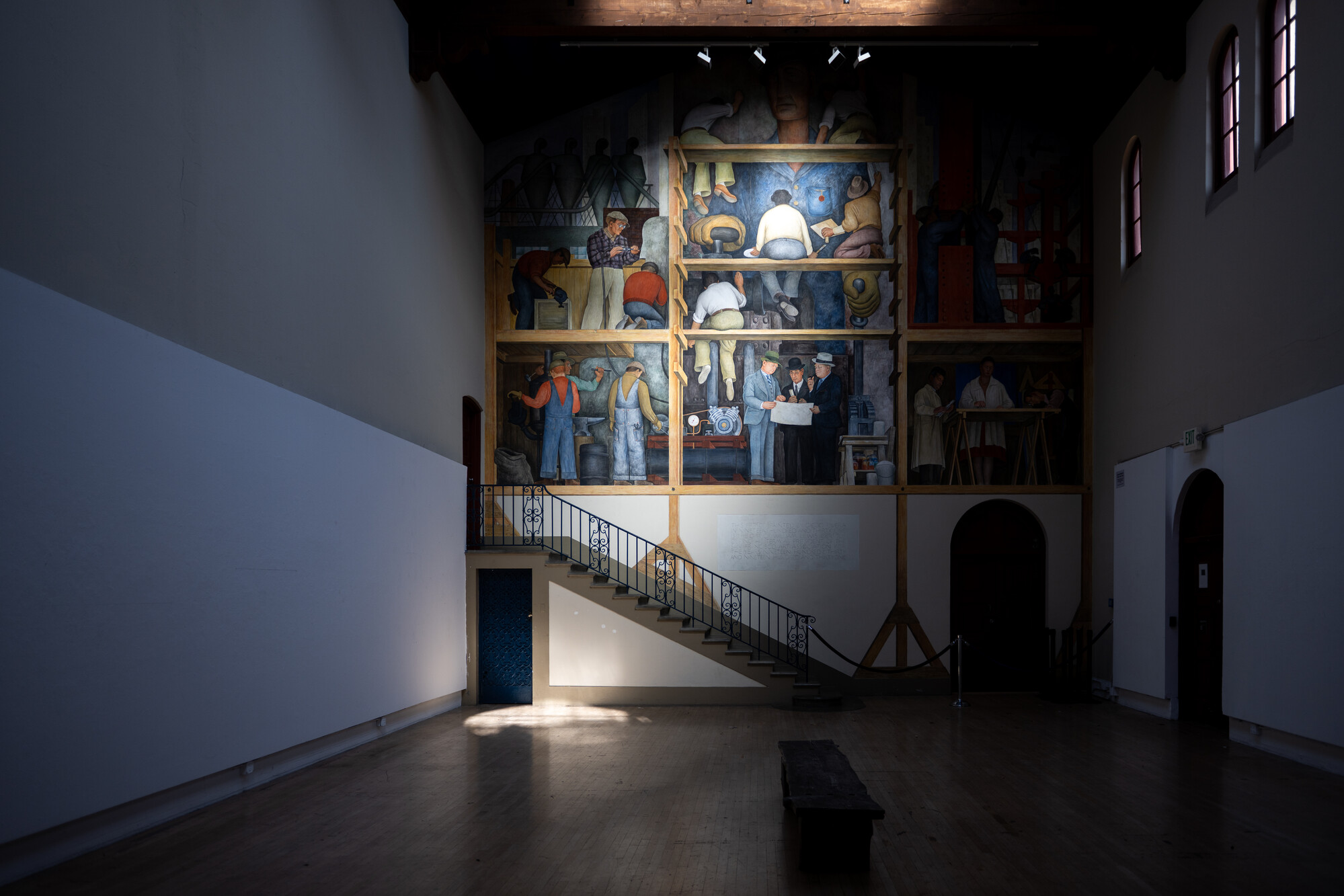 dramatically lit fresco on back wall of high-ceilinged long room